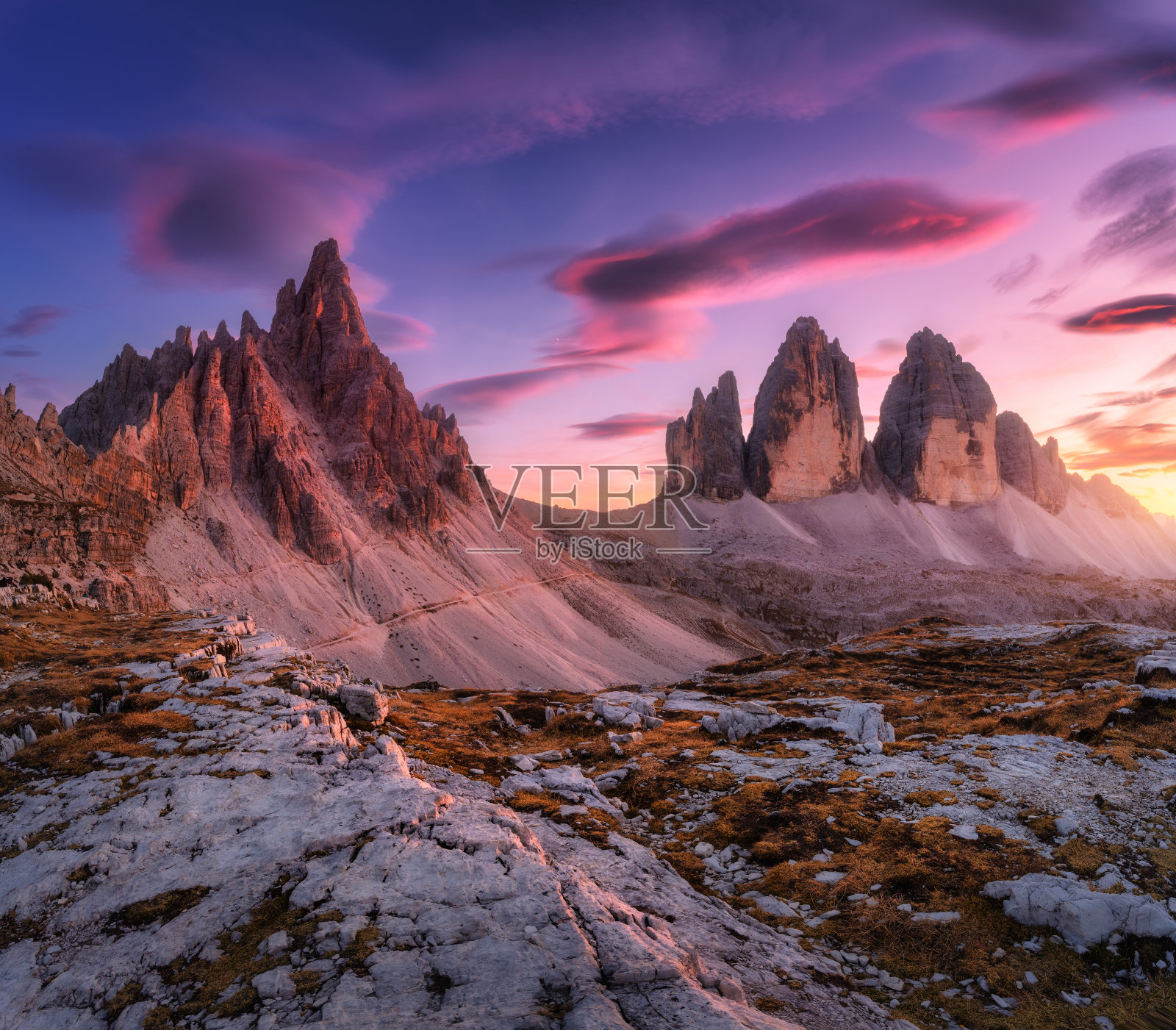 意大利多洛米蒂的特莱姆，秋天的高山日落。五彩缤纷的景观，岩石和石头，小径，橙色的草，紫色的天空和粉红色的云在秋天的黄昏。阿尔卑斯山脉。自然照片摄影图片
