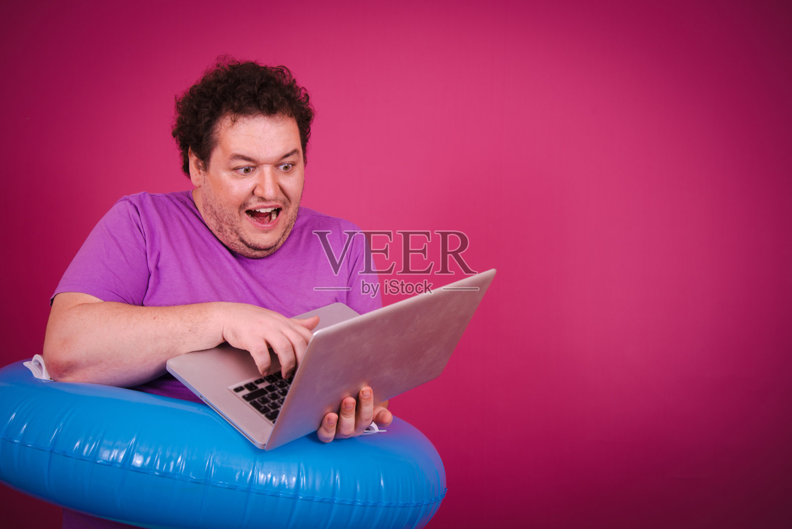 带着充气戒指在海上度假的滑稽胖子。照片摄影图片