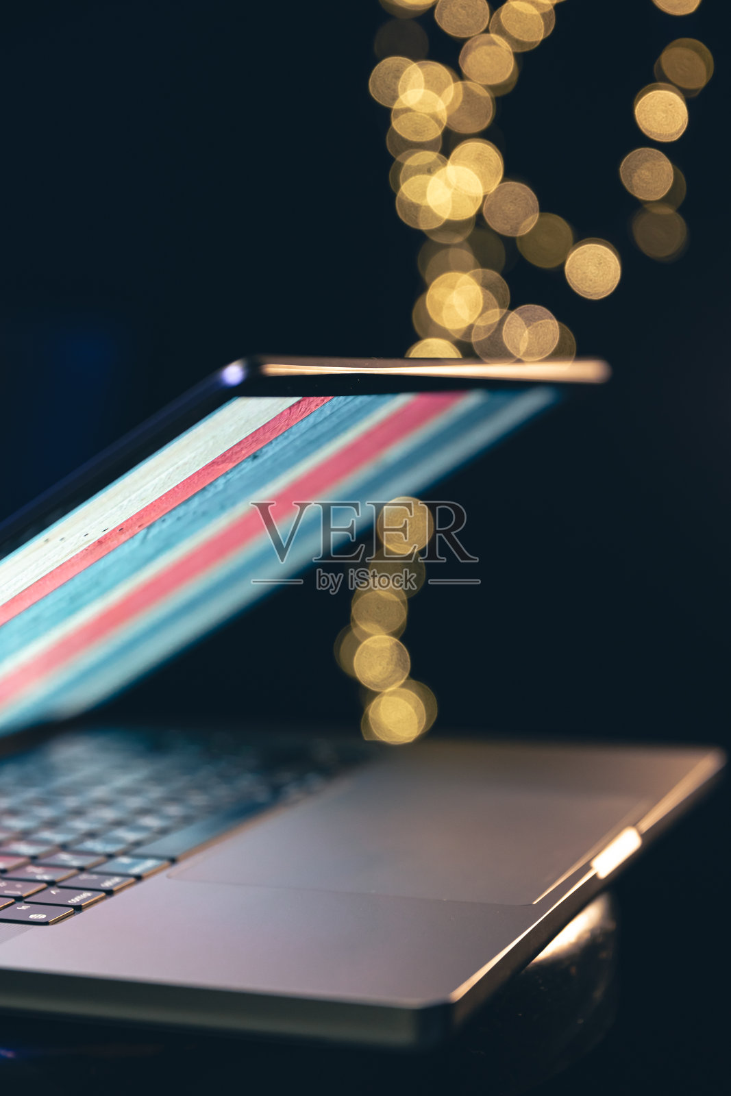 特写，笔记本电脑在带有散景的深色背景上。照片摄影图片