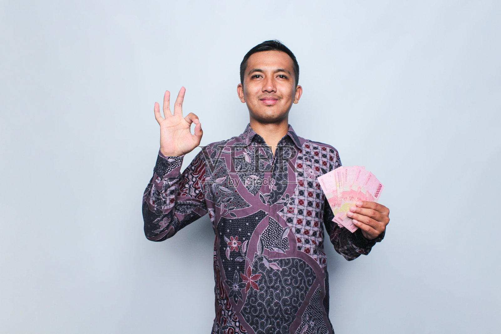 穿着印尼蜡染衬衫的亚洲年轻人。照片摄影图片