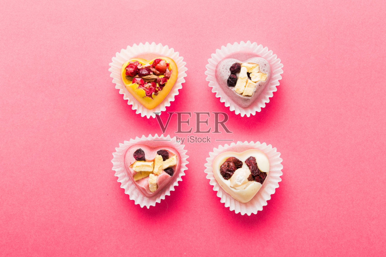 巧克力糖果，心形形状，水果和坚果在彩色背景上。顶视图与空间的文字，假期的概念照片摄影图片