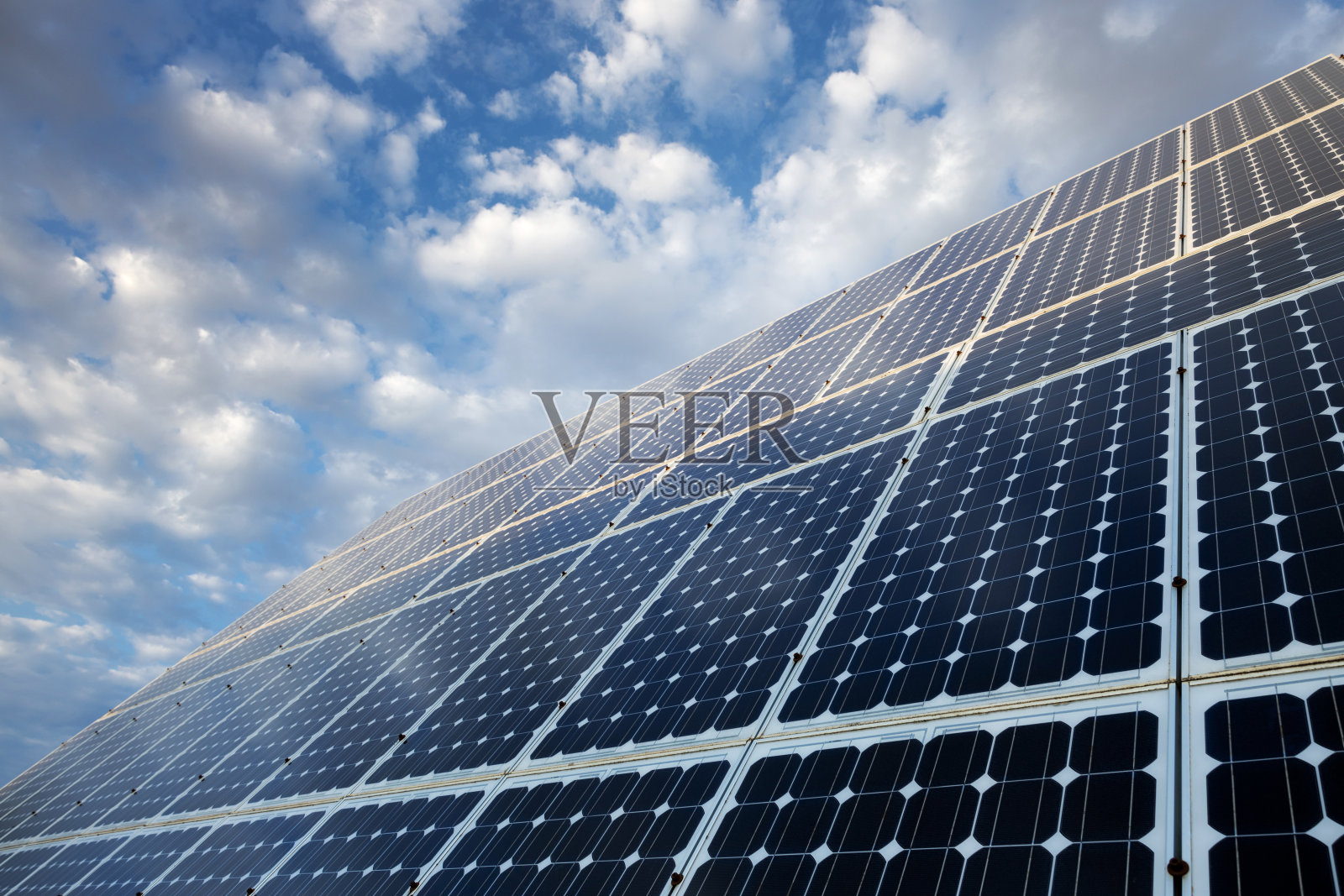 太阳能电池板和蓝色多云天空的特写细节。照片摄影图片