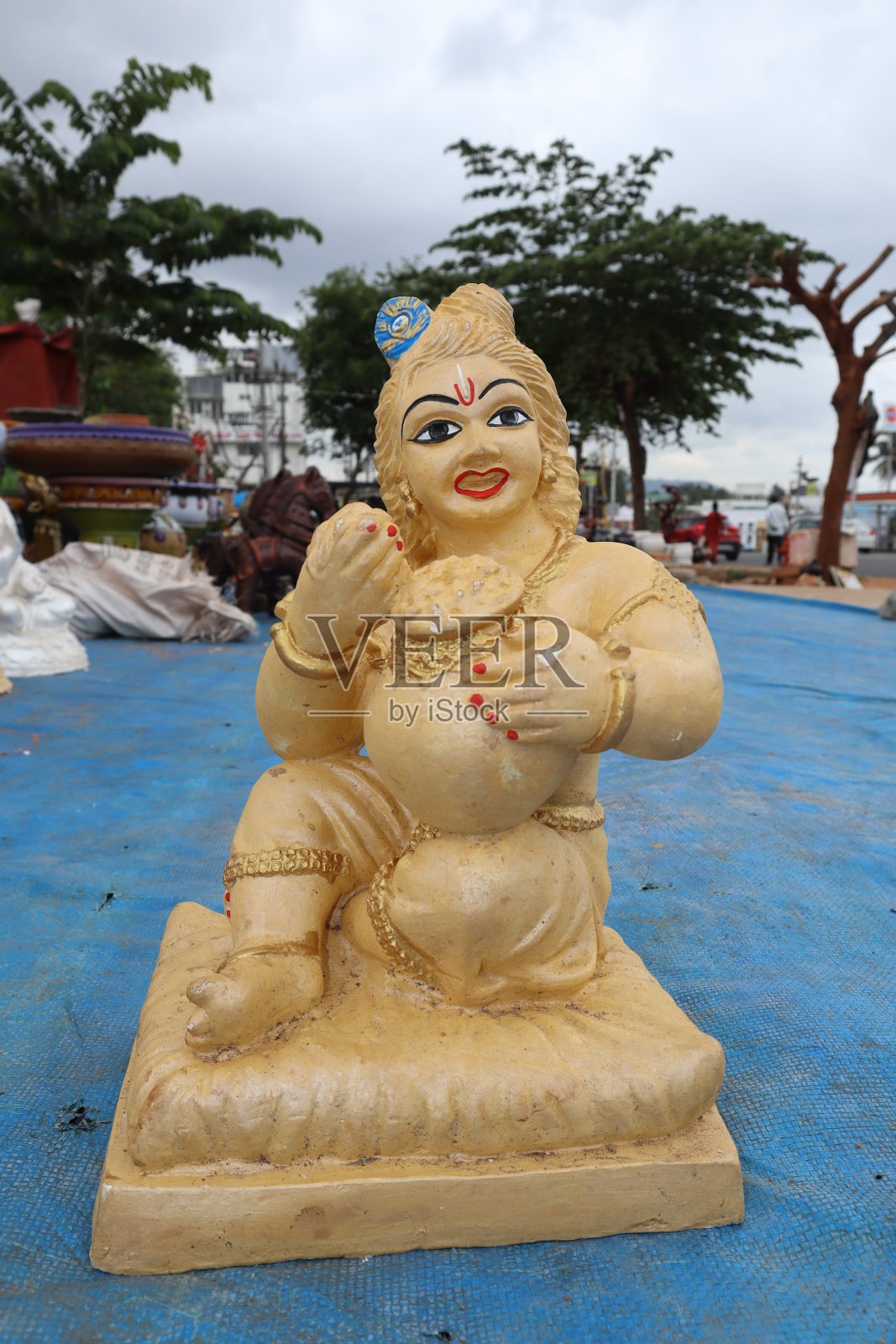 一个经典的粘土雕像，描绘了婴儿主克里希纳在印度的克里希纳节上吃凝乳。照片摄影图片