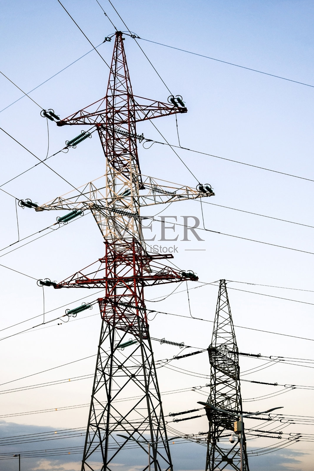 高压电线的金属塔架映衬着夜空。照片摄影图片