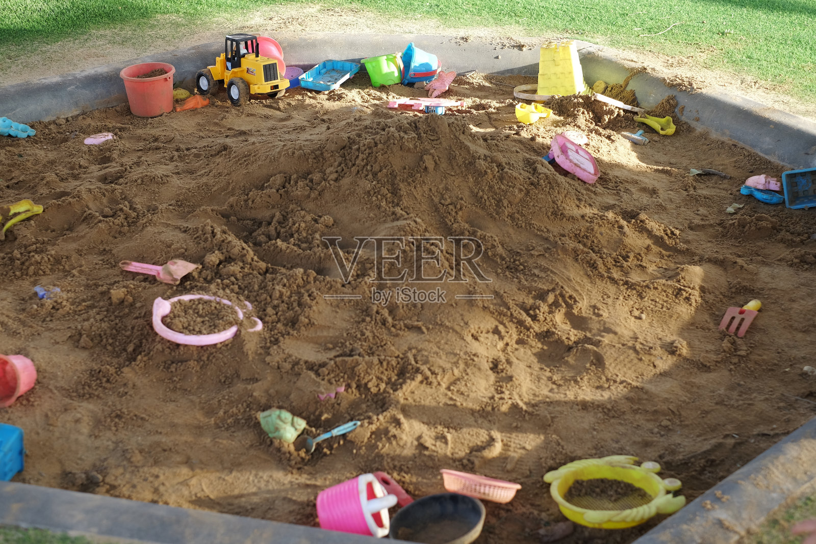 操场上的儿童沙箱景观，孩子们可以用卡车、汽车、挖掘机和挖沙车玩玩具。照片摄影图片