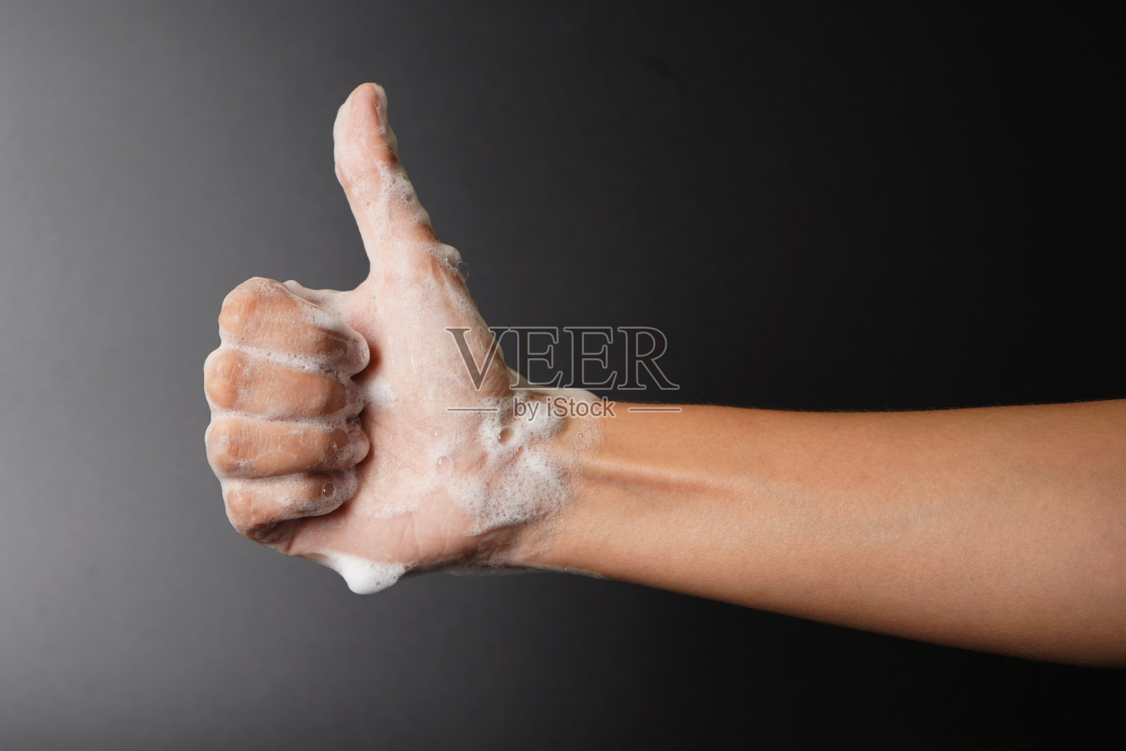 泡沫手竖起大拇指的手势，洗手的概念照片摄影图片