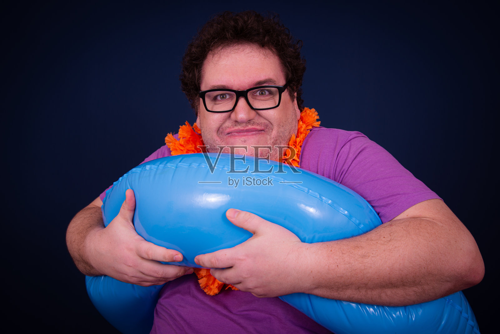 假期和节假日。带着充气戒指的滑稽胖子照片摄影图片