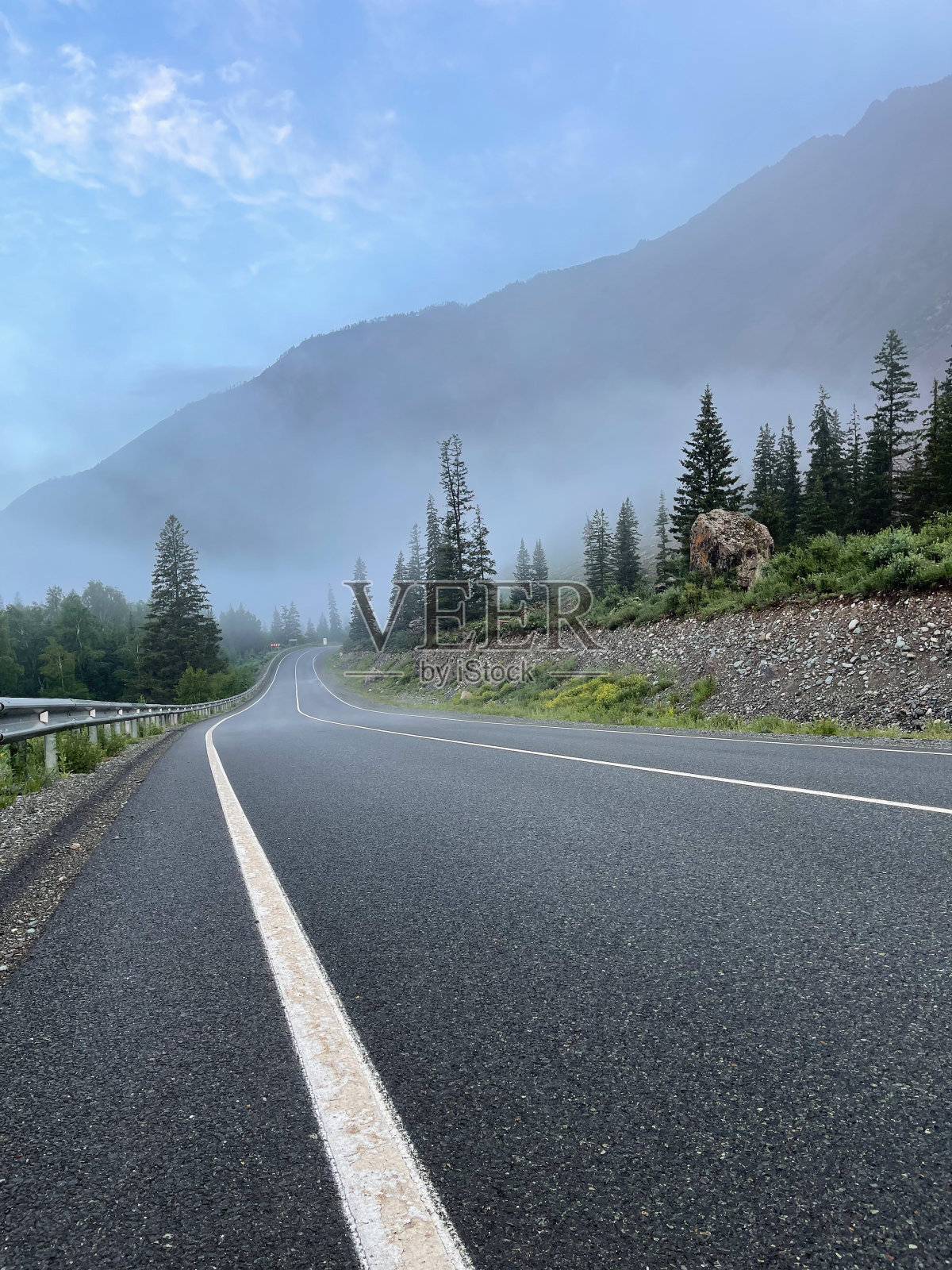 公路在山与雾和树木在前景。照片摄影图片
