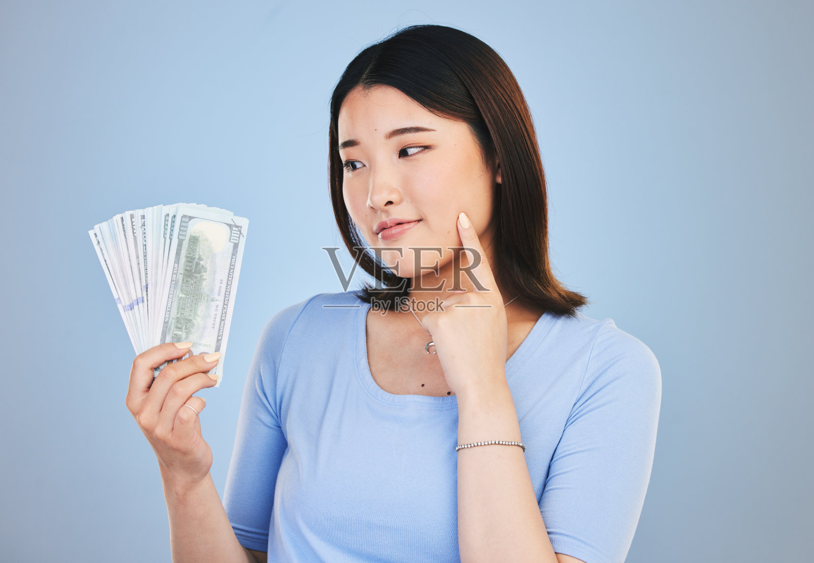 女人，金钱和赢家，想到奖金，财务上的成功和获胜，金融贷款或选择。亚洲人或客户的现金，储蓄决策或利润的想法在蓝色，工作室背景照片摄影图片