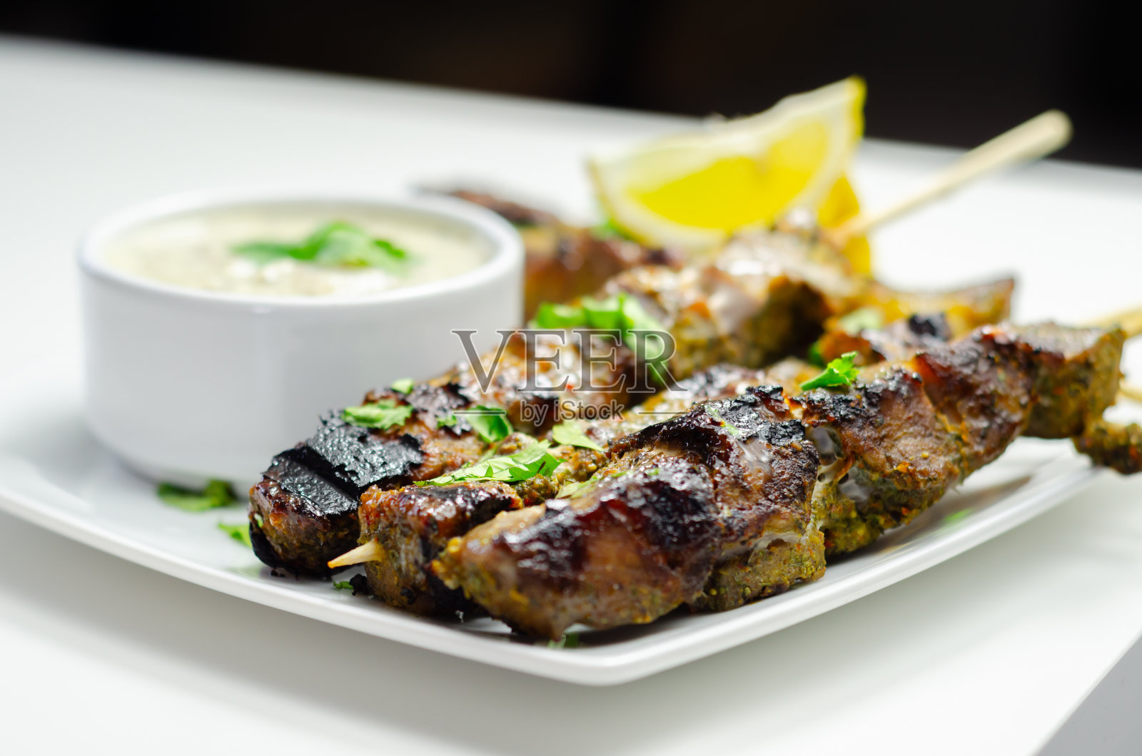 猪肩肉串配柠檬香草酱和大蒜薄荷酸奶酱照片摄影图片