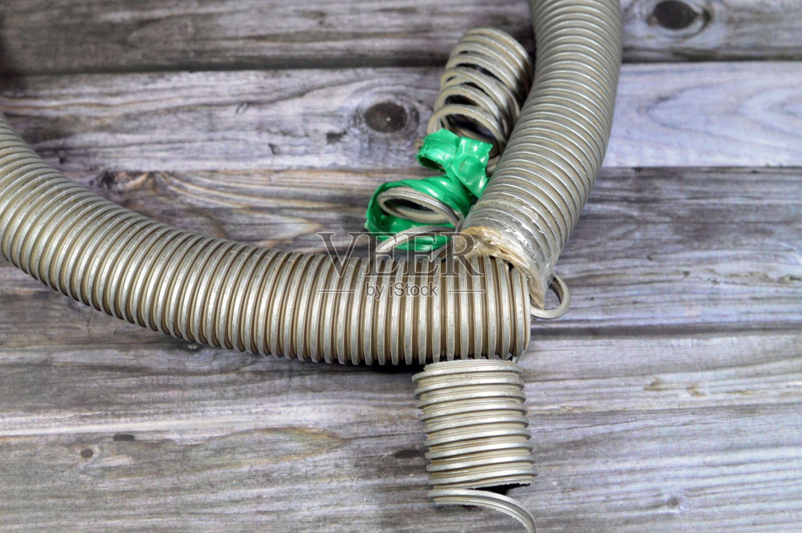 真空吸尘器破损的软管，劣质材料与维护服务概念照片摄影图片