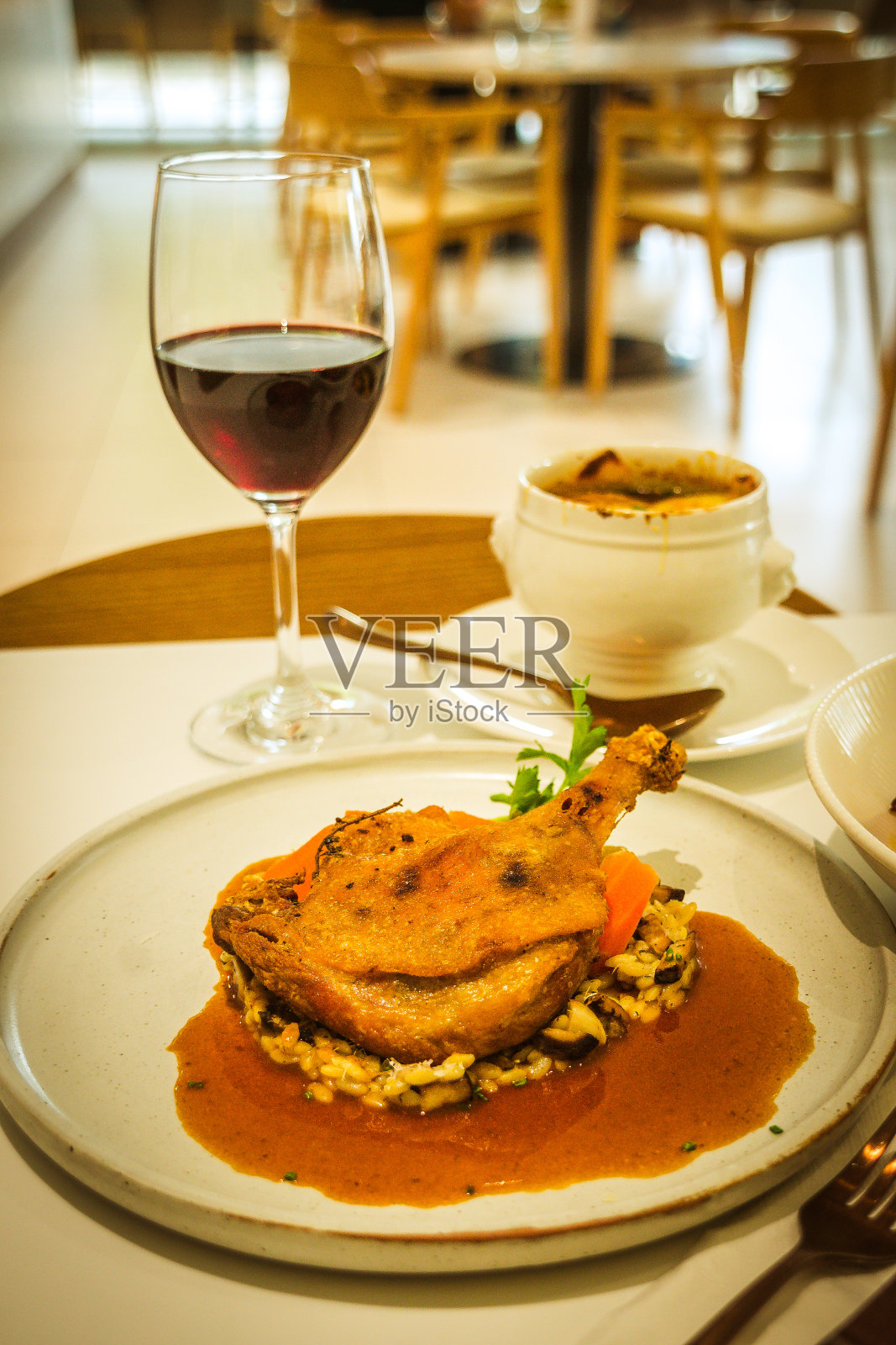 油封鸭腿配烩饭和胡萝卜照片摄影图片