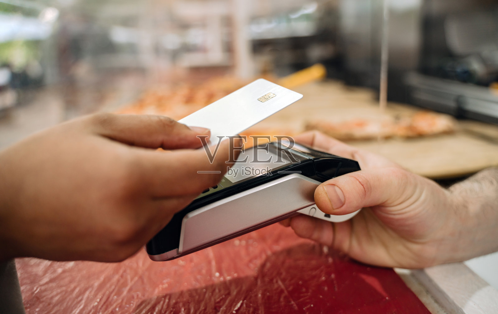 顾客手持信用卡付款。无线技术概念照片摄影图片