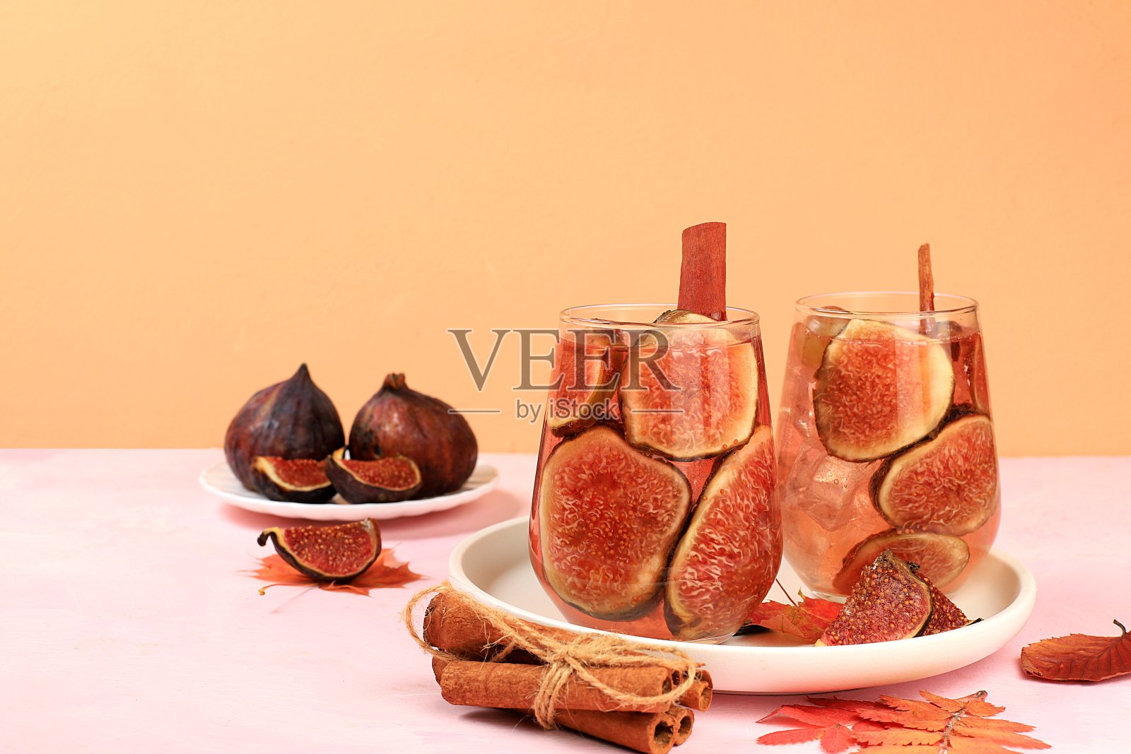 以无花果、肉桂、葡萄和秋叶为背景的鸡尾酒，流感和寒冷季节的暖性维生素酒精和非酒精饮料，格罗酒、苹果酒、柠檬水。照片摄影图片