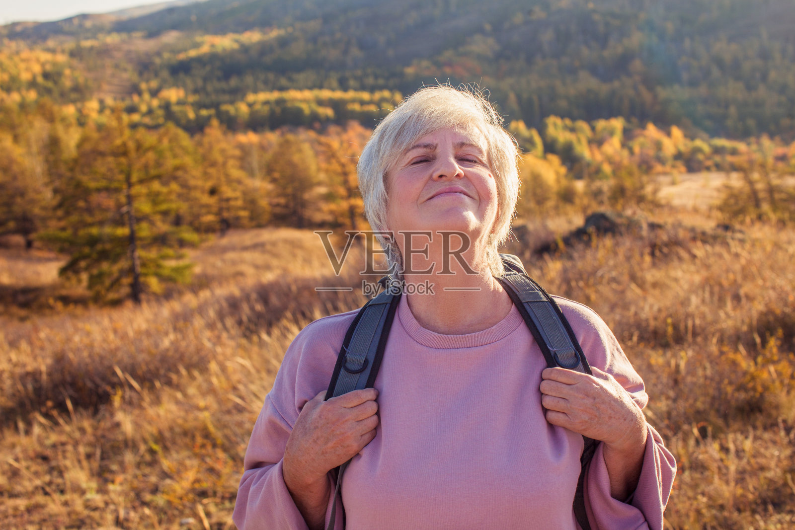 中年妇女在秋天的森林里徒步和露营照片摄影图片