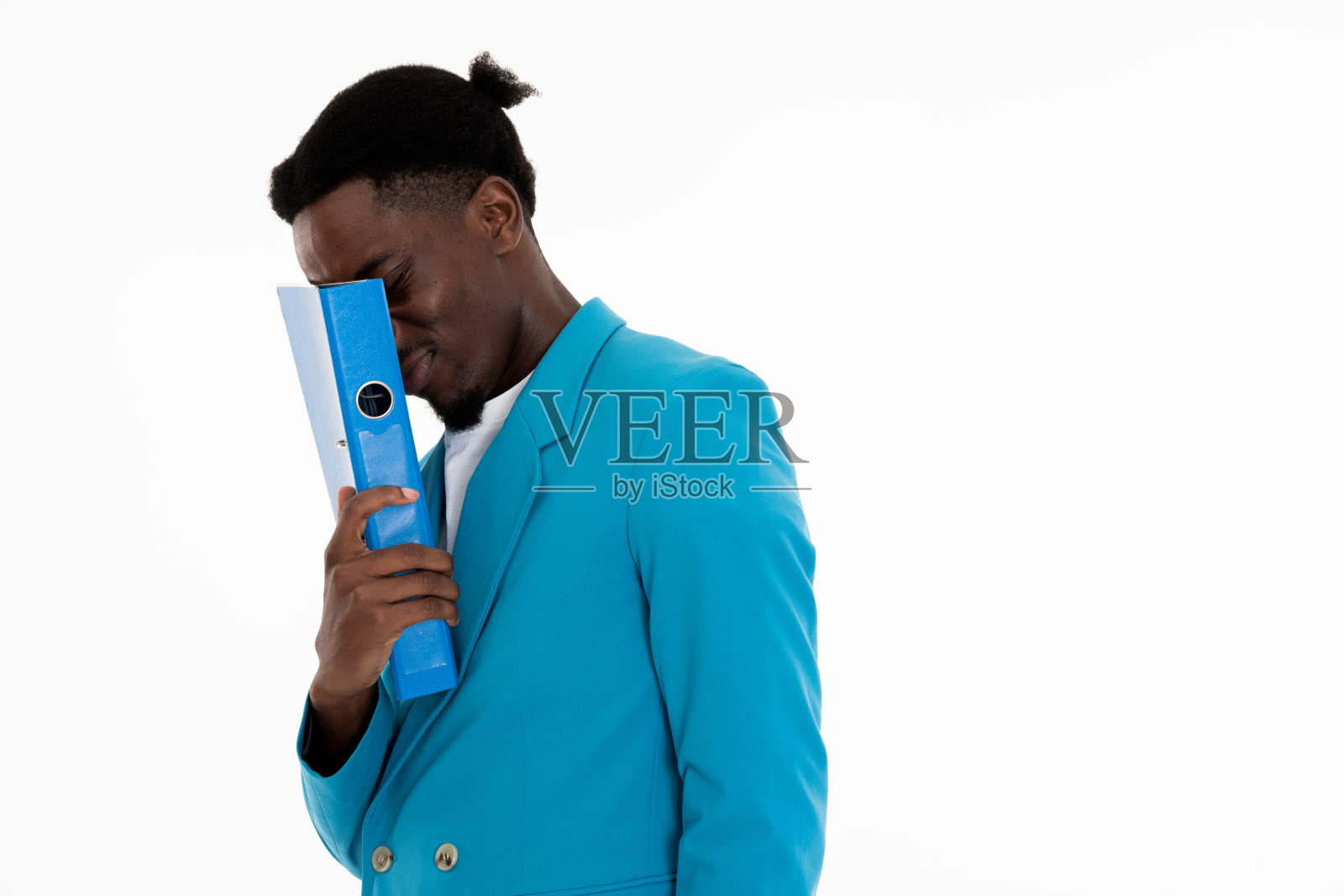 一头雾水的黑皮肤男子，手里拿着文件夹，摸着脸，发型滑稽，穿着蓝色西装和白色t恤照片摄影图片