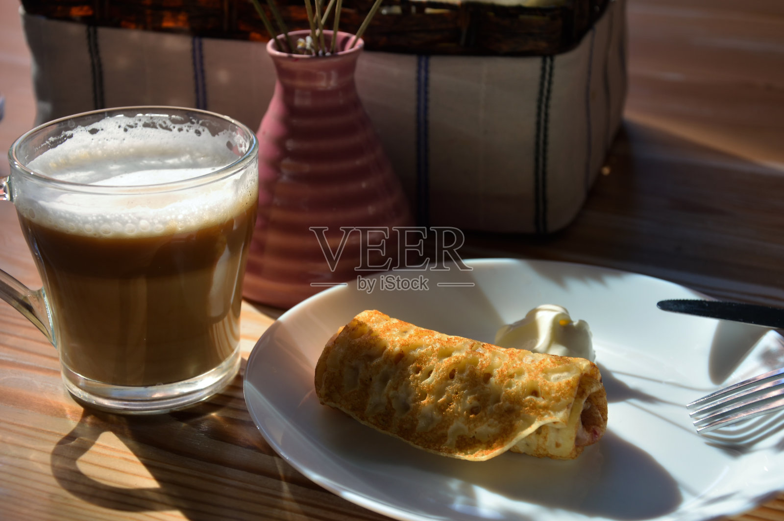 美味的早餐，白色盘子里放着酸奶油煎饼，木桌上放着一杯新鲜咖啡。设计背景。美味的食物。照片摄影图片