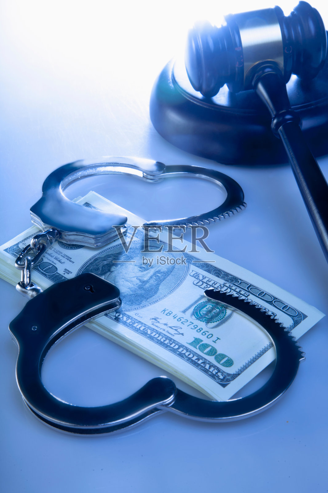 美元纸币、手铐和法官的木槌，象征司法系统的腐败照片摄影图片