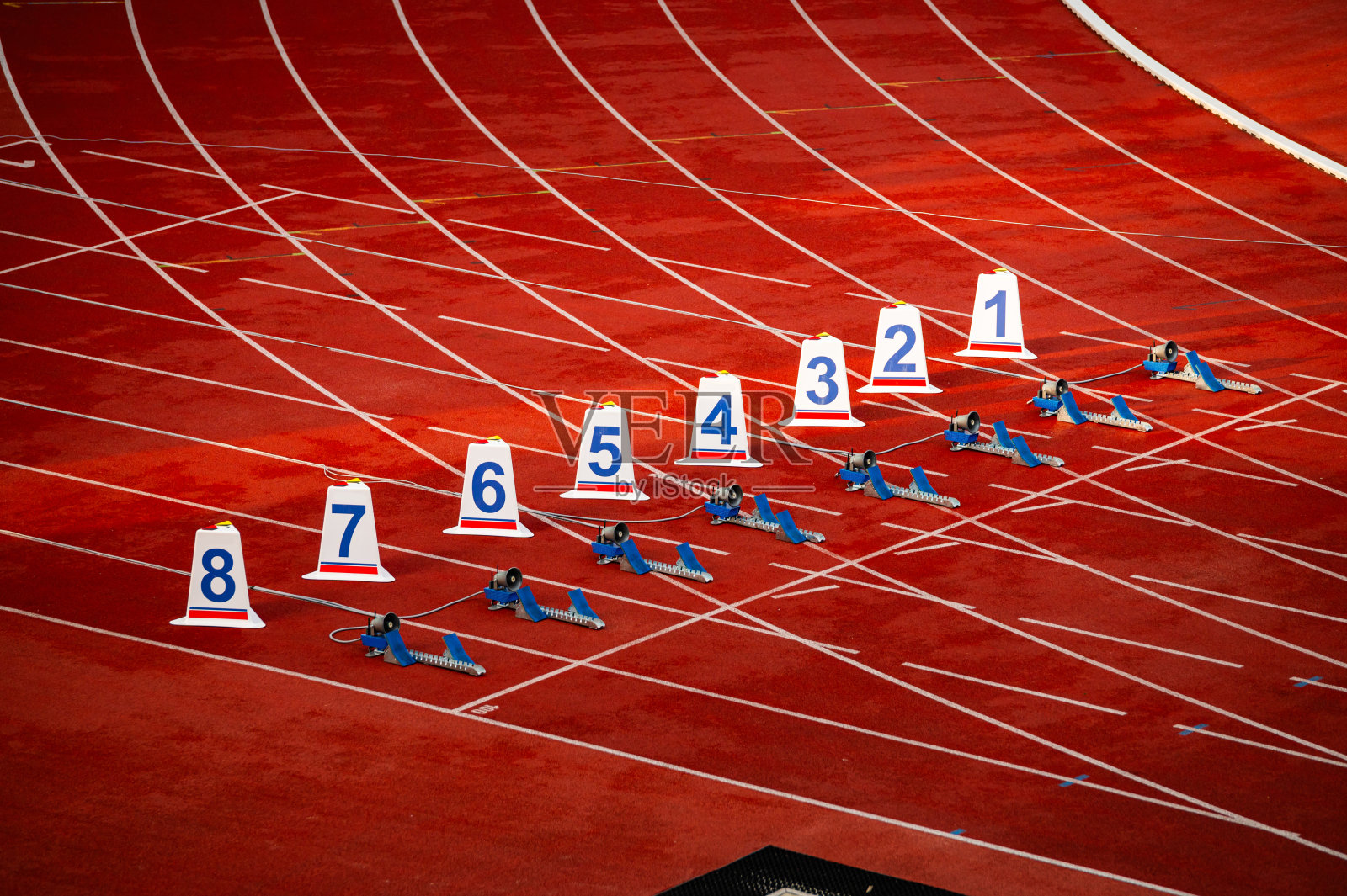 短跑比赛开始。红色跑道上的数字和起跑线。田径体育场。田径照片。田径跑道上的起始数字。照片摄影图片