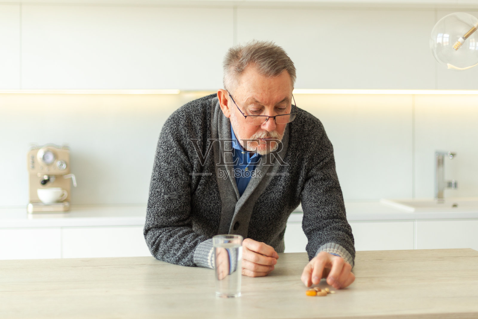 手拿药丸和水杯的中老年男人照片摄影图片