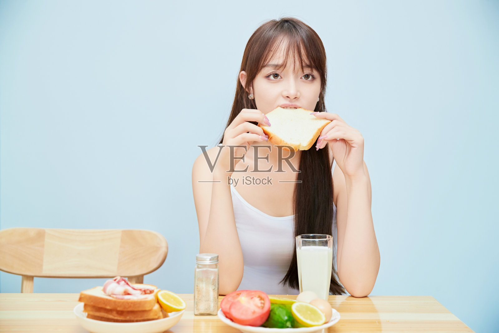 一个年轻的亚洲女孩在餐桌上吃早餐照片摄影图片