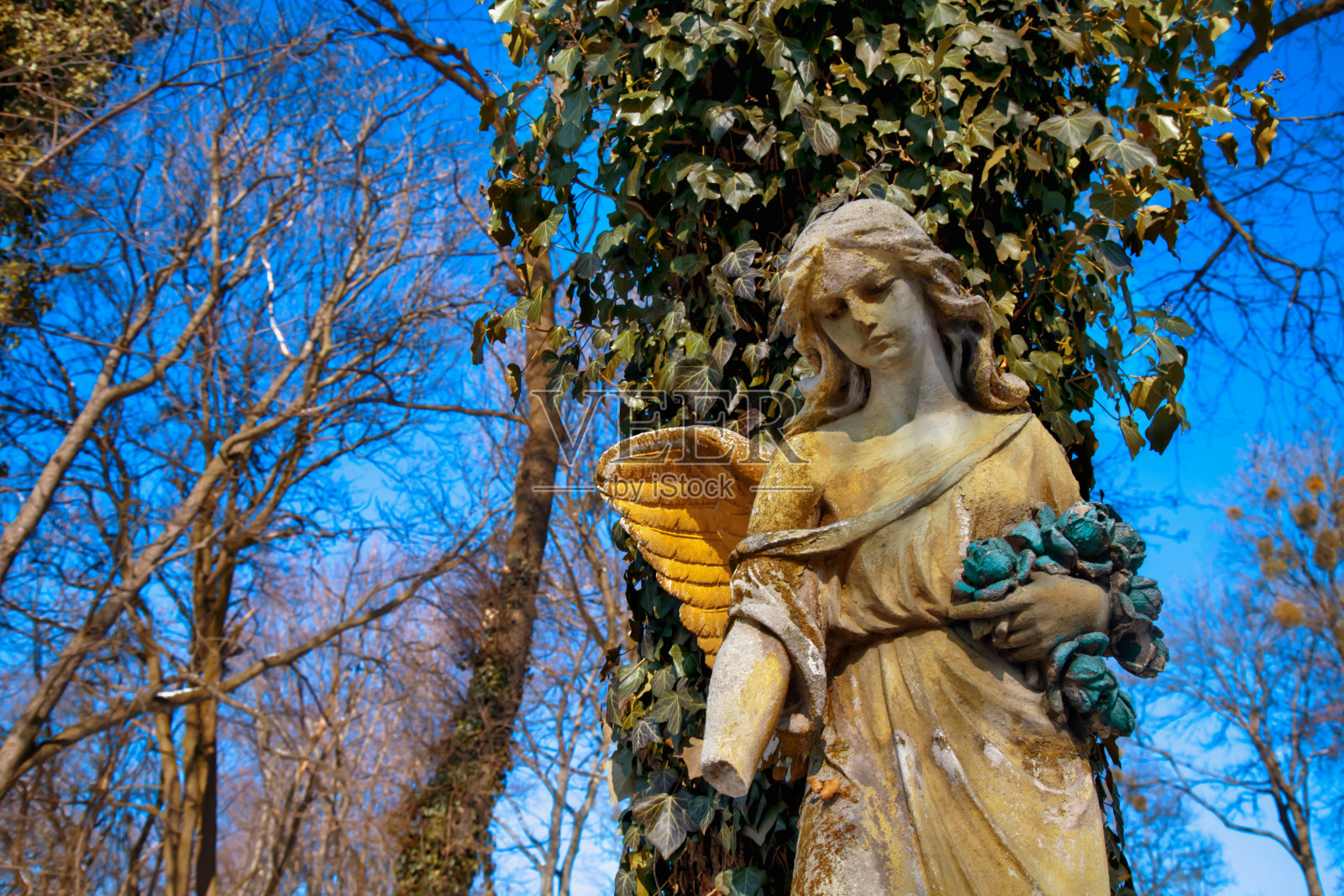 金色天使雕像的壮丽景色被阳光照亮，背景是蓝天。照片摄影图片