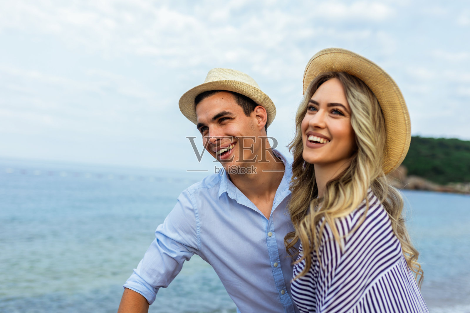 幸福的年轻夫妇在海滩上笑着拥抱照片摄影图片