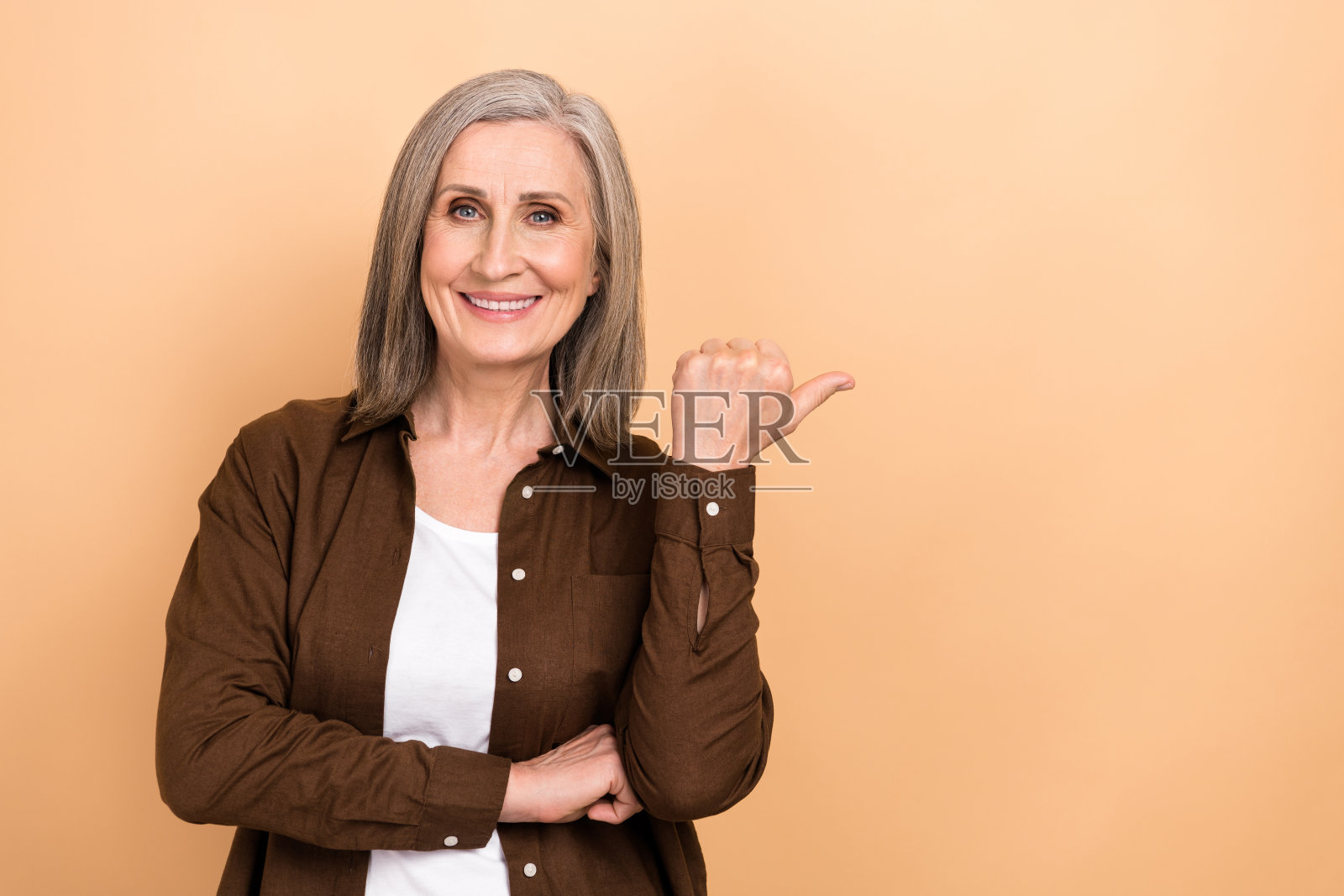 乐观开朗的好人的肖像，穿着时尚的夹克，在米色背景上显示空白空间的推广照片摄影图片