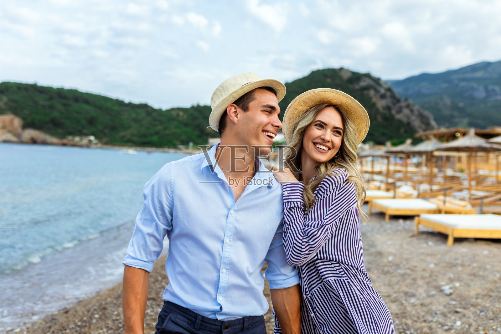 幸福的年轻夫妇在海滩上笑着拥抱照片摄影图片