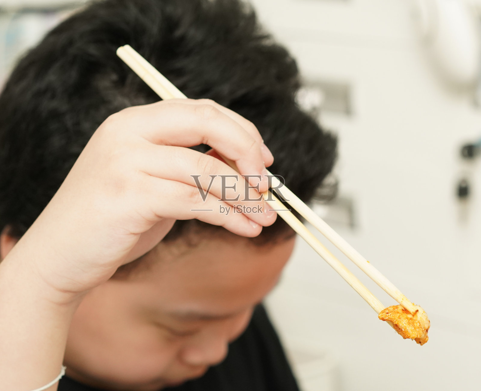 小朋友用筷子夹食物照片摄影图片