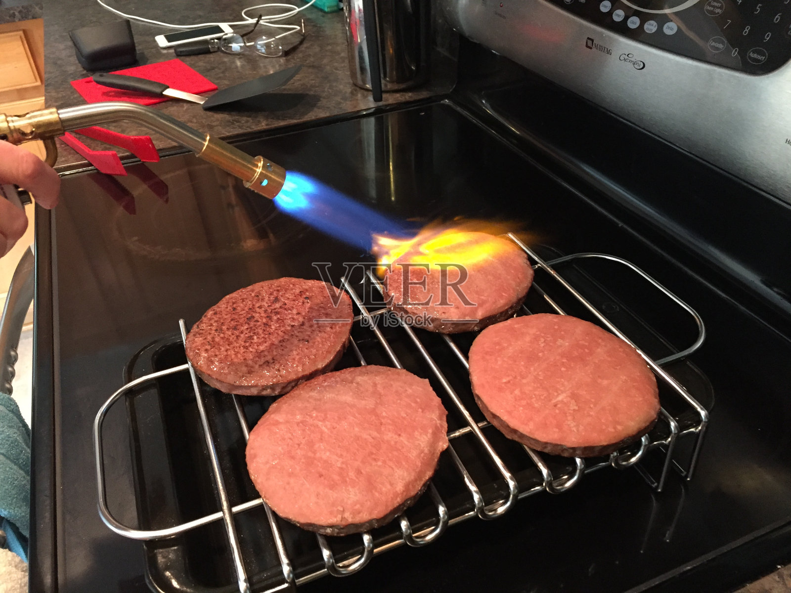 用真空烹调后在汉堡上加炭。照片摄影图片