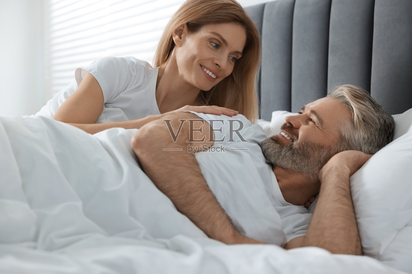 可爱的成熟夫妻在家里的床上照片摄影图片