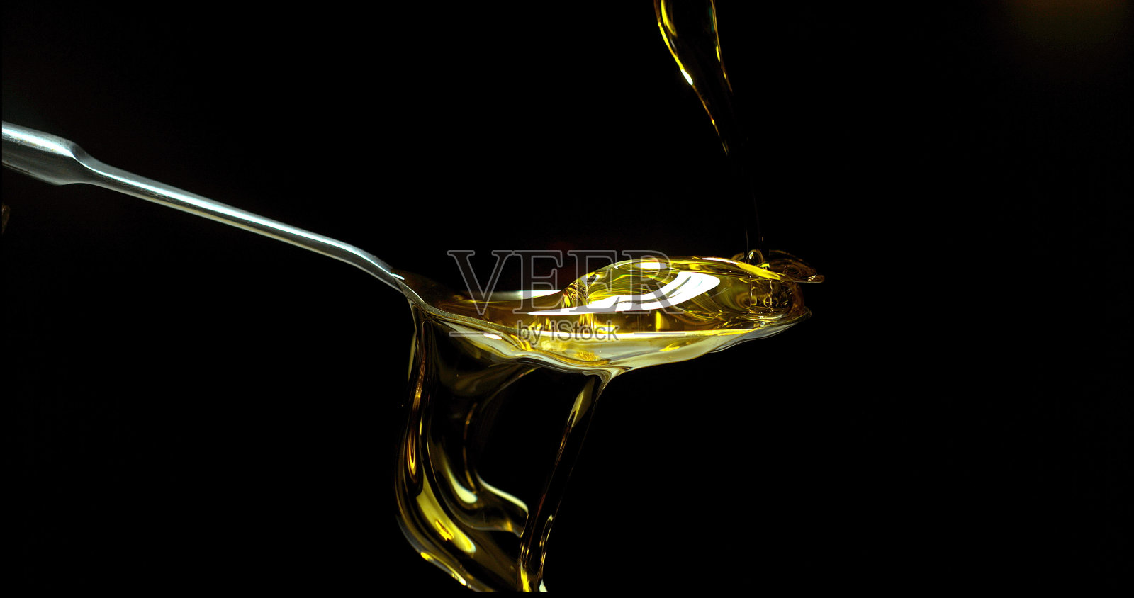 橄榄油，倒在勺子里，黑色背景照片摄影图片