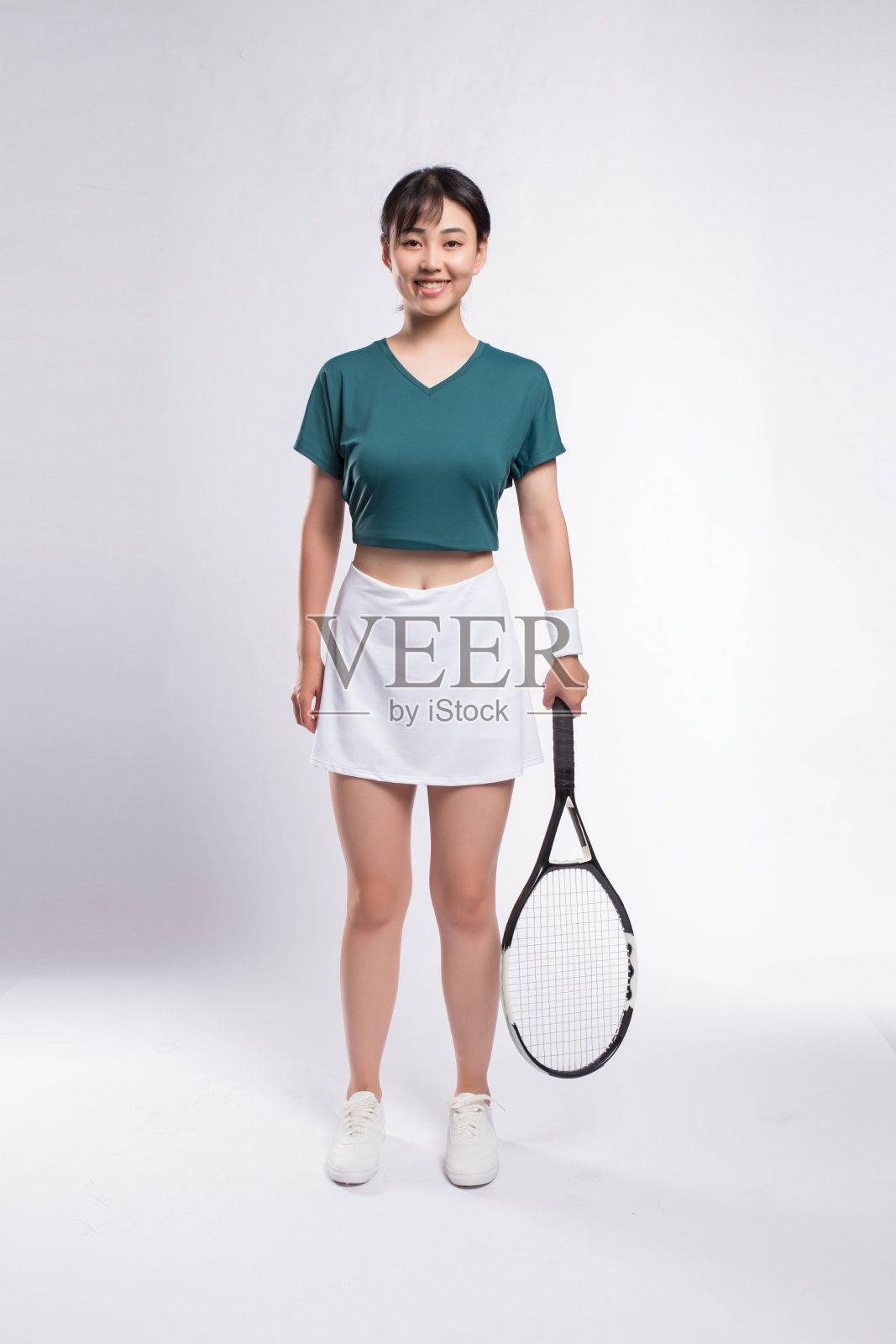 身穿网球服的女子在灰色背景下进行网球训练照片摄影图片