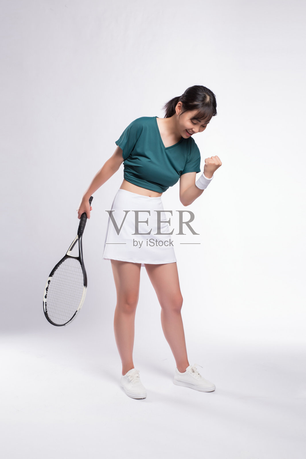 身穿网球服的女子在灰色背景下进行网球训练照片摄影图片