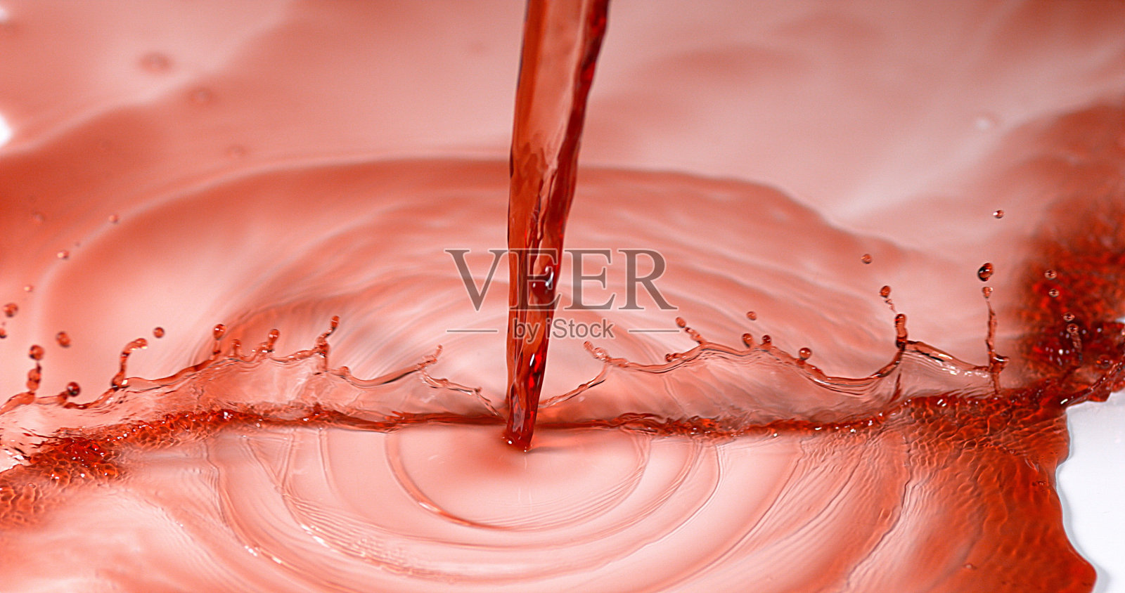 红酒倒在白色的背景上照片摄影图片