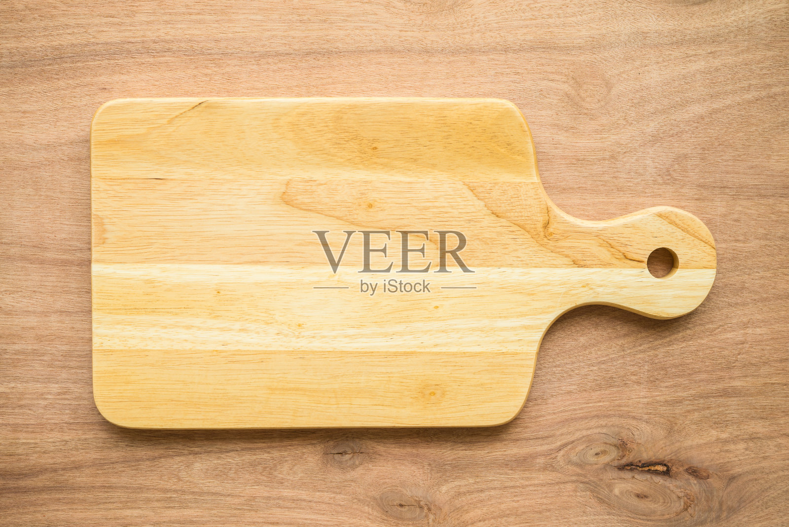 木桌背景上未使用的新棕色手工木制砧板的顶视图。照片摄影图片