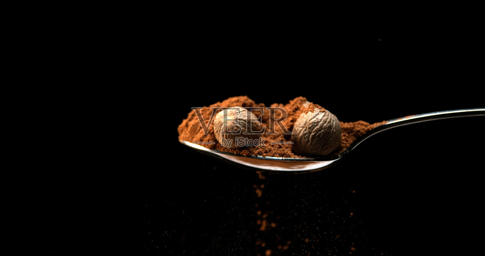 肉豆蔻，肉豆蔻，坚果落在粉末黑色背景照片摄影图片