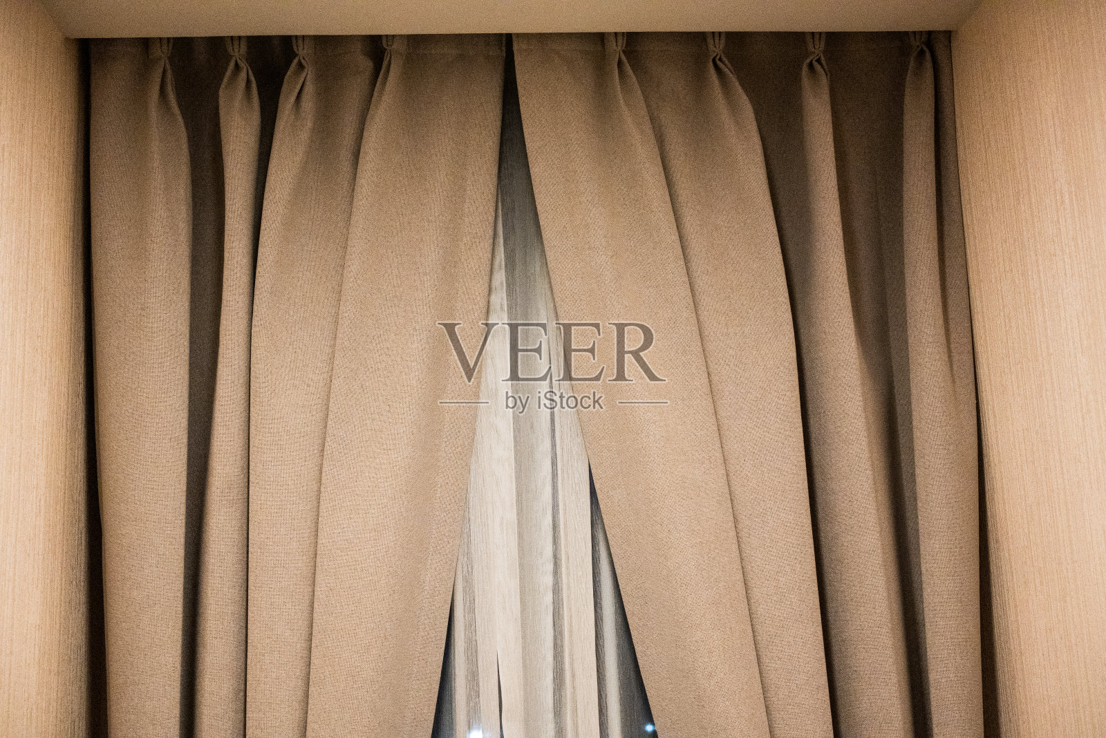 室内的窗户上挂着褐色的窗帘。照片摄影图片