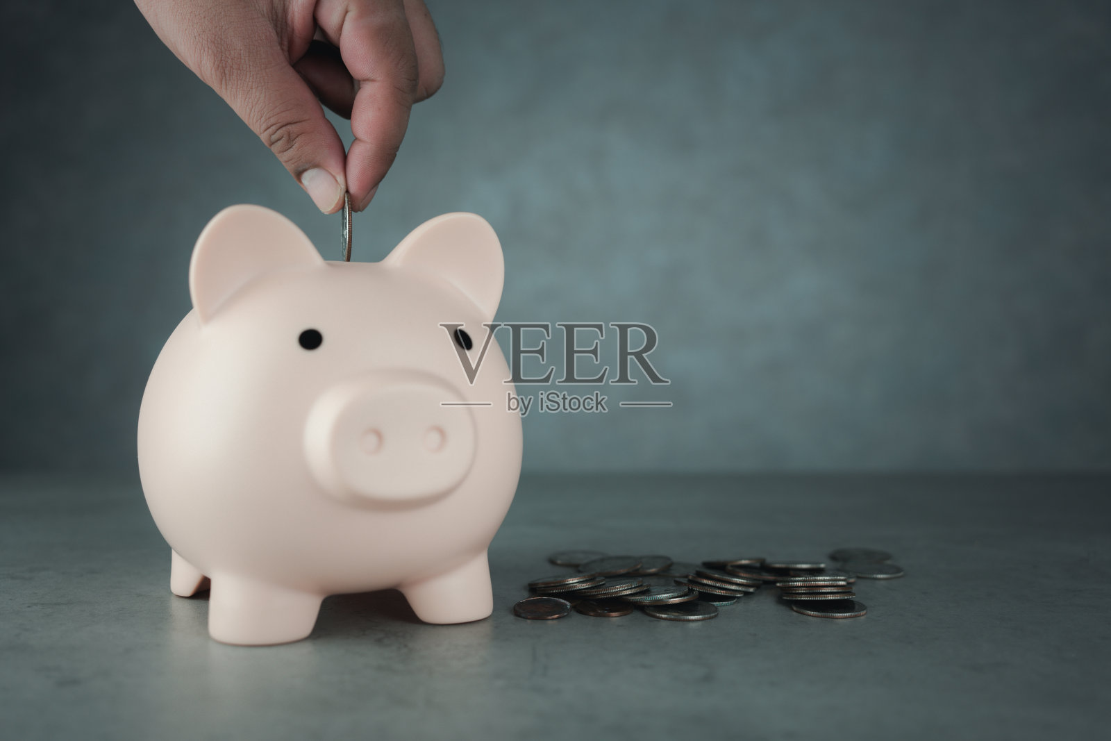 一个人把一枚硬币放进存钱罐里作为储蓄或投资的特写照片摄影图片