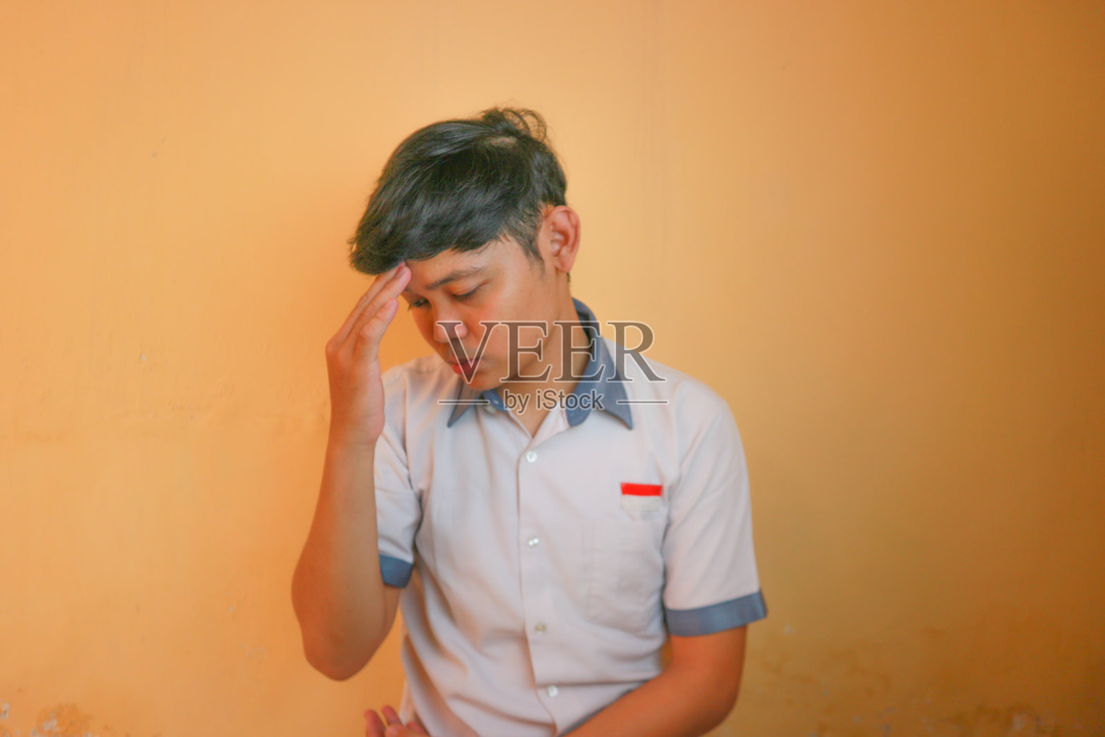 印尼高中男生穿灰色和白色的校服。孤立在黄色背景上，有着非常多样的表情照片摄影图片