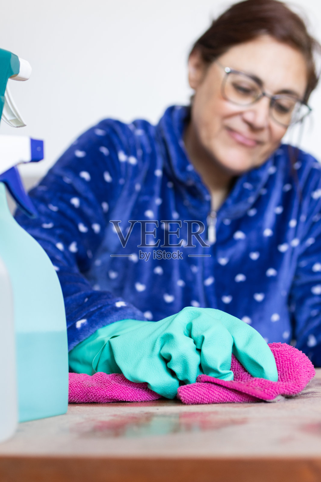 快乐的女人用清洁用品和抹布打扫房子（竖版图片）照片摄影图片