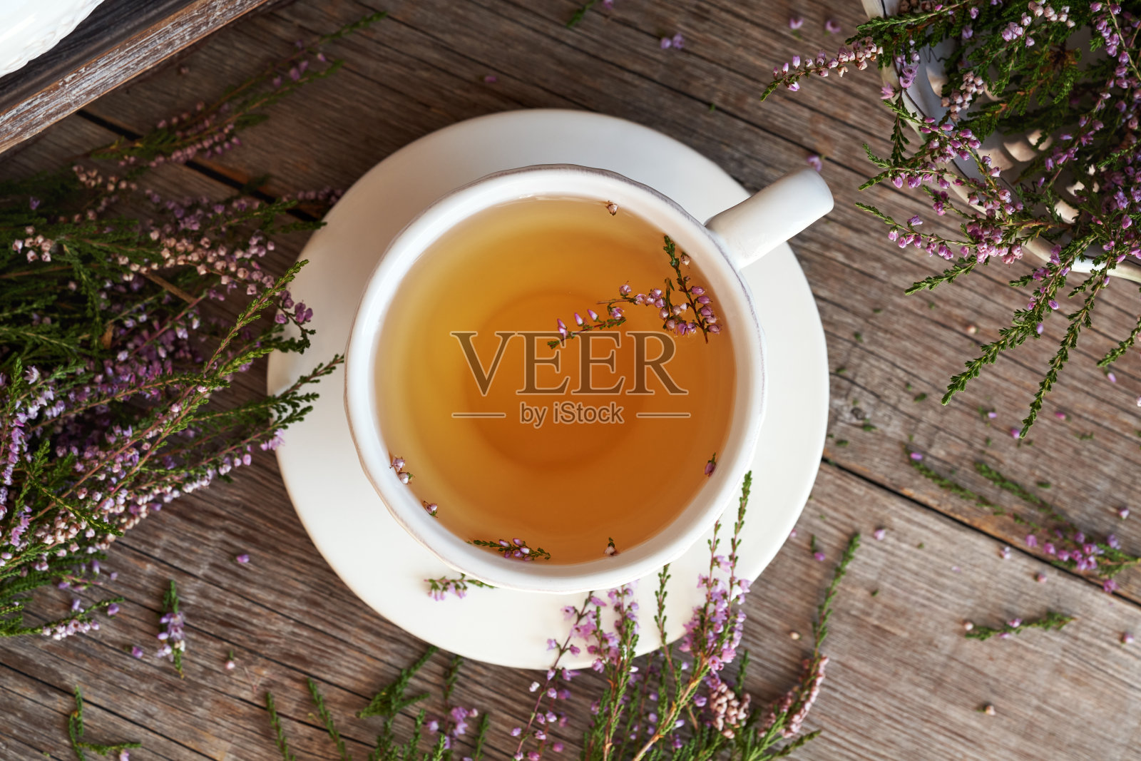 木桌上白色杯子里的石南茶，俯视图照片摄影图片