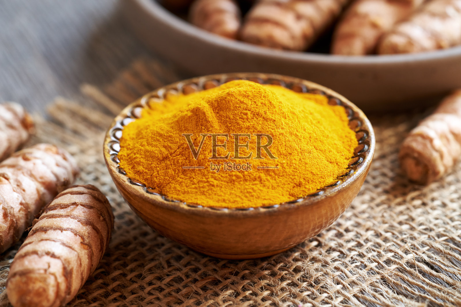 姜黄粉和姜根放在桌子上照片摄影图片