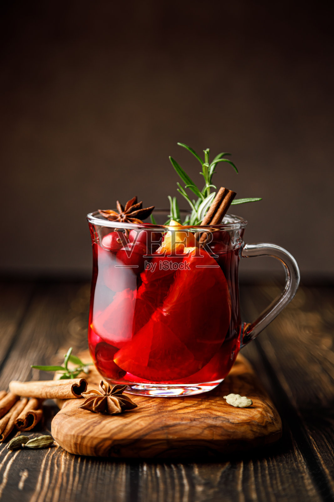 圣诞热葡萄酒配蔓越莓，橘子，肉桂，茴香和迷迭香。传统热饮或饮料，节日圣诞或新年冬季鸡尾酒照片摄影图片