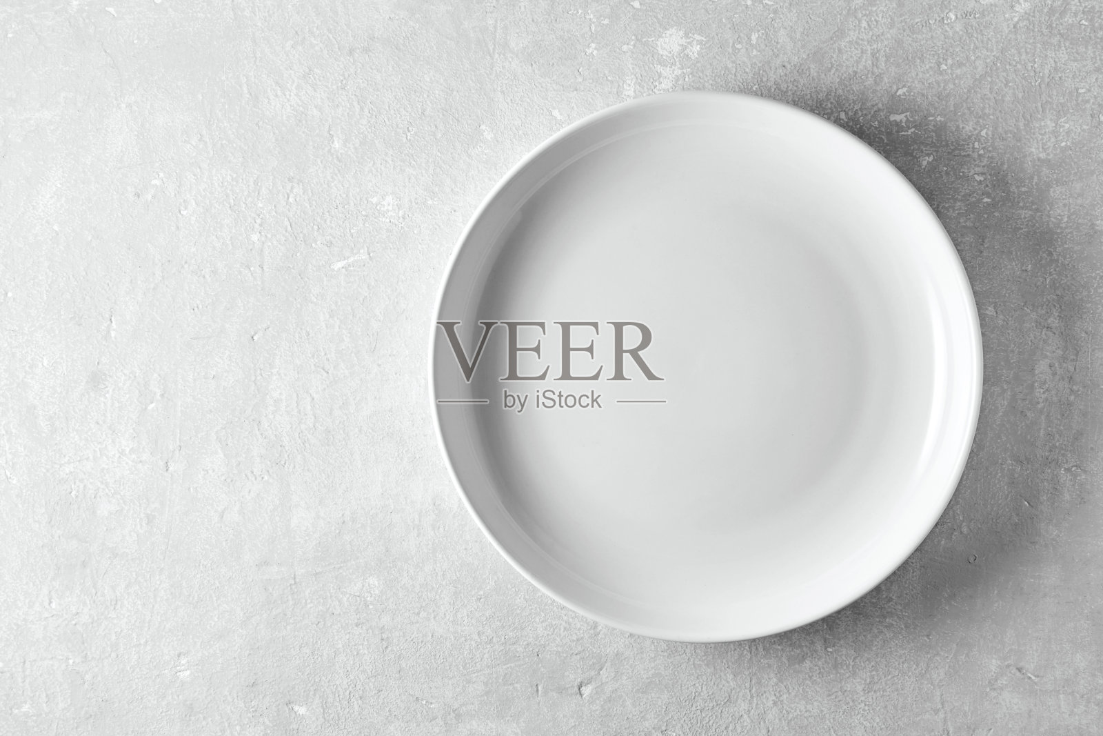 灰色石头背景上的白色空盘子。在菜单上显示食物的模板照片摄影图片