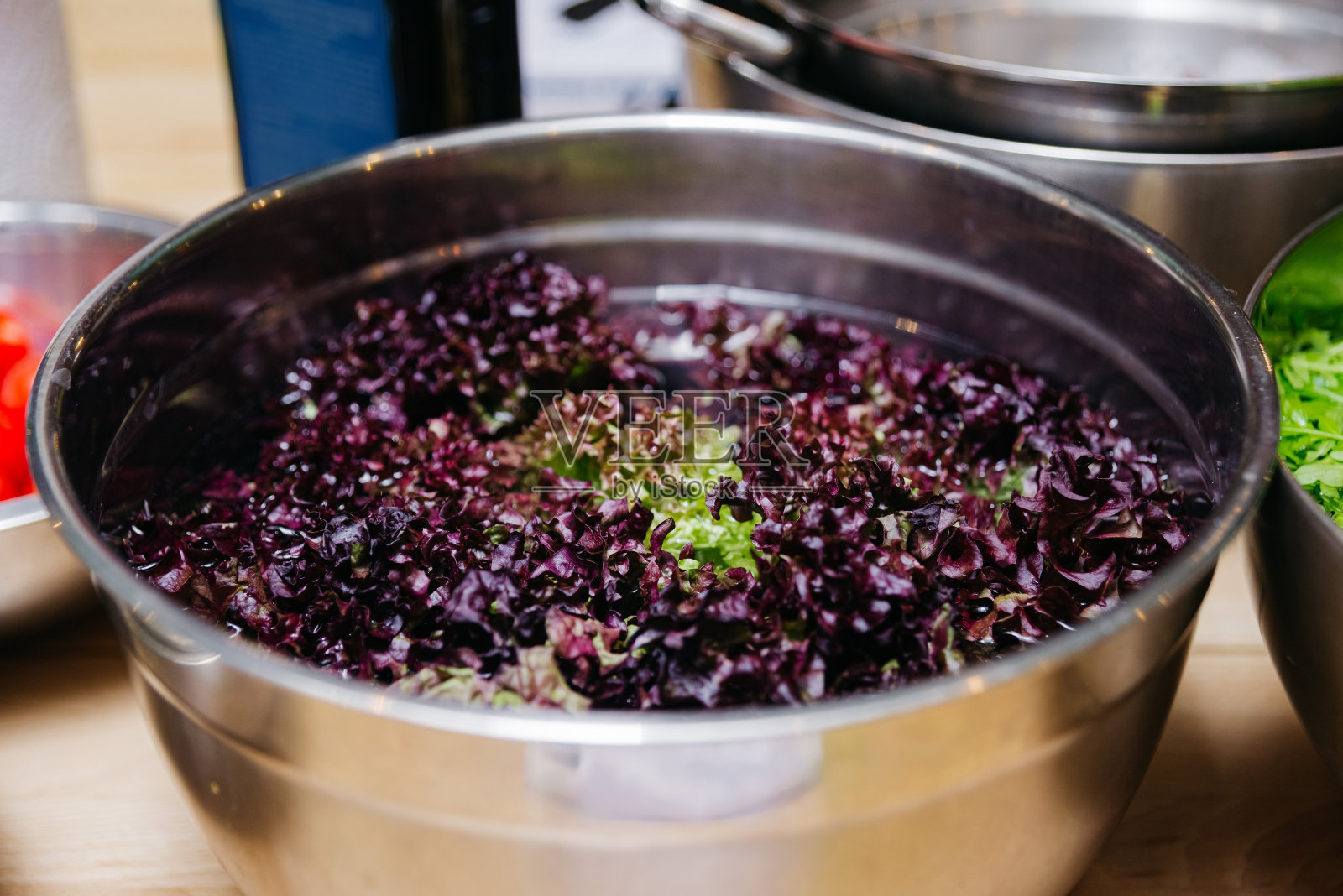 不锈钢碗里的新鲜红生菜沙拉照片摄影图片