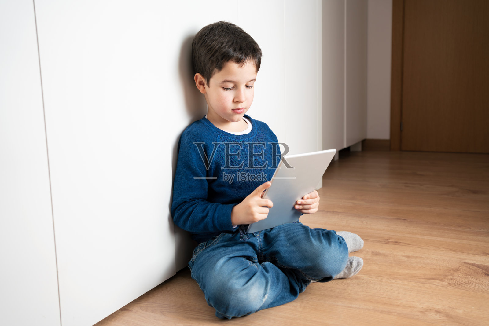 玩平板电脑的孤独儿童照片摄影图片