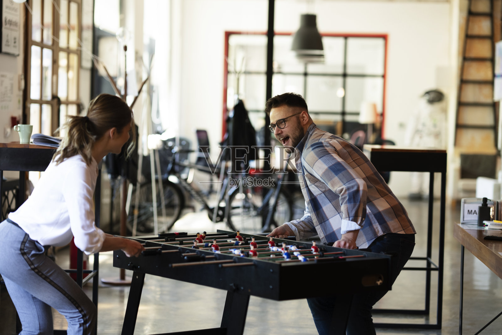 商人和女商人在玩桌上足球照片摄影图片
