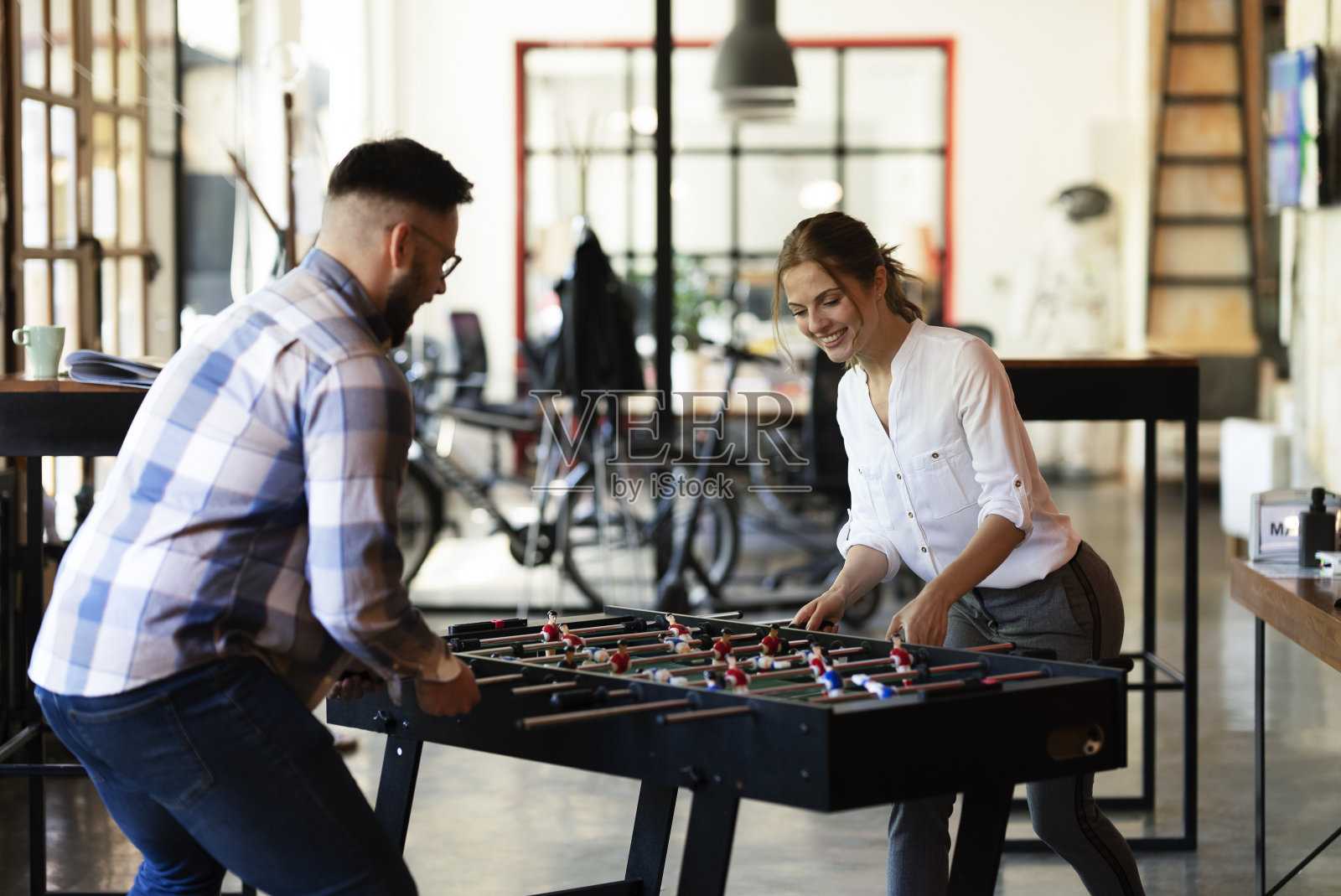 商人和女商人在玩桌上足球照片摄影图片